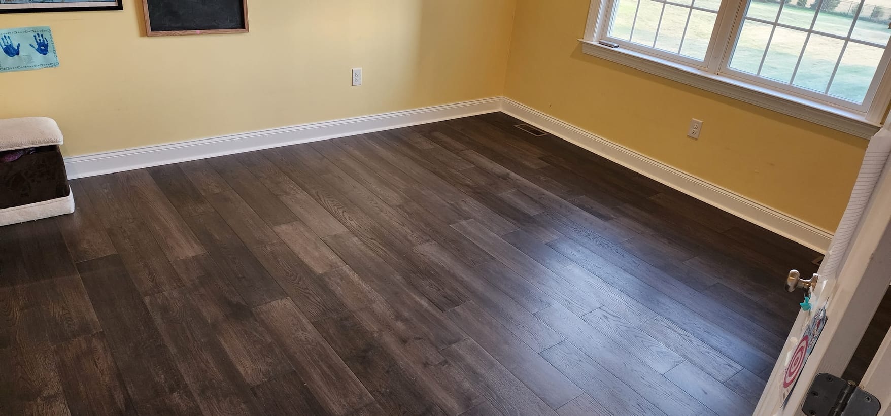 Dark hardwood floor install in a sunlit room by Frankie D’s Flooring