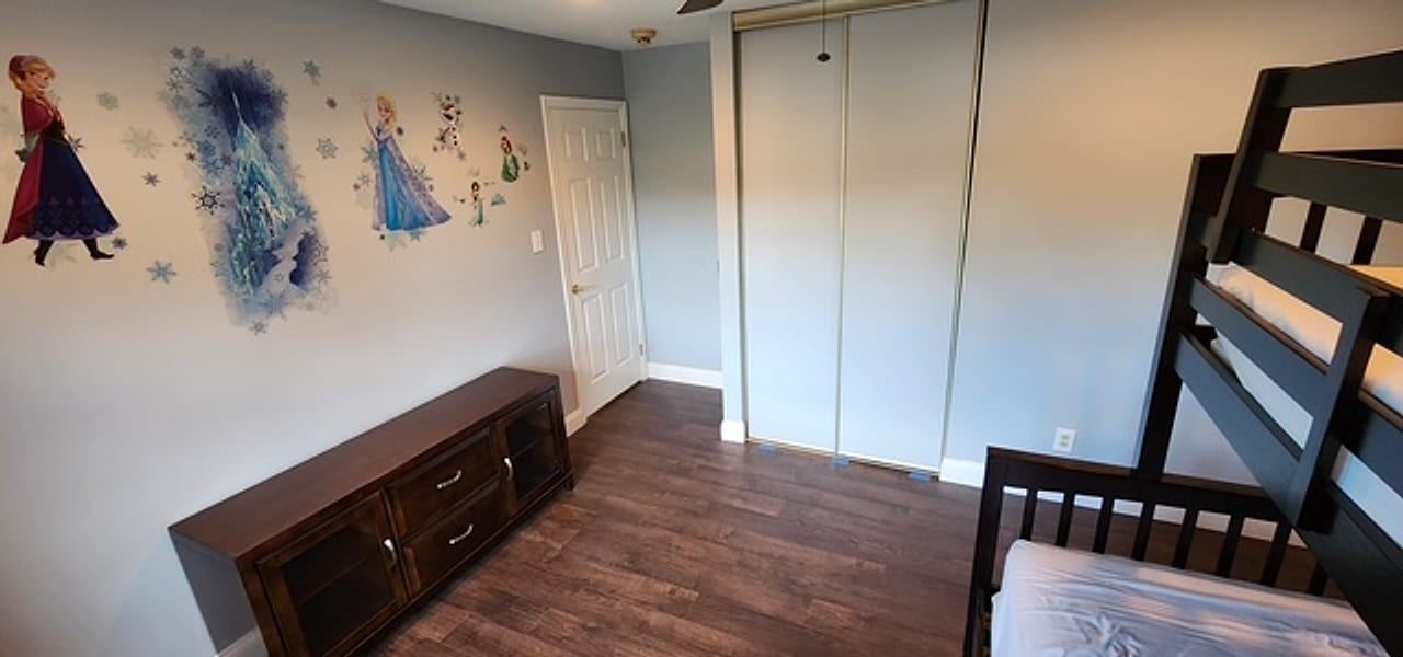 Dark plank flooring running into the closet of a kids’ bedroom by Frankie D’s Flooring