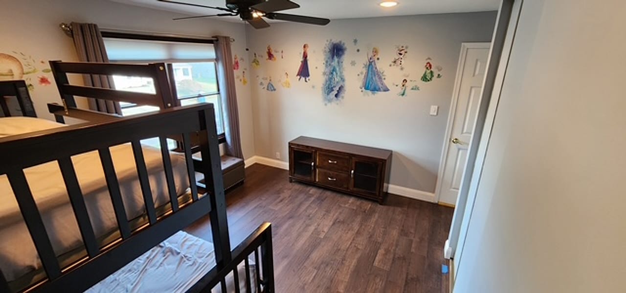 Dark plank flooring wall to wall in a kids’ bedroom by Frankie D’s Flooring